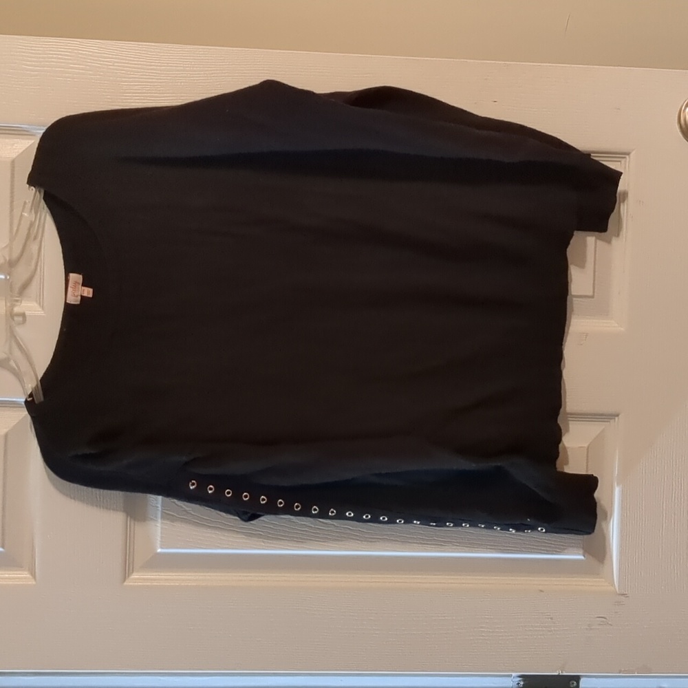 Black sweater with cute grommet detailing along both sleeves. Gently used.